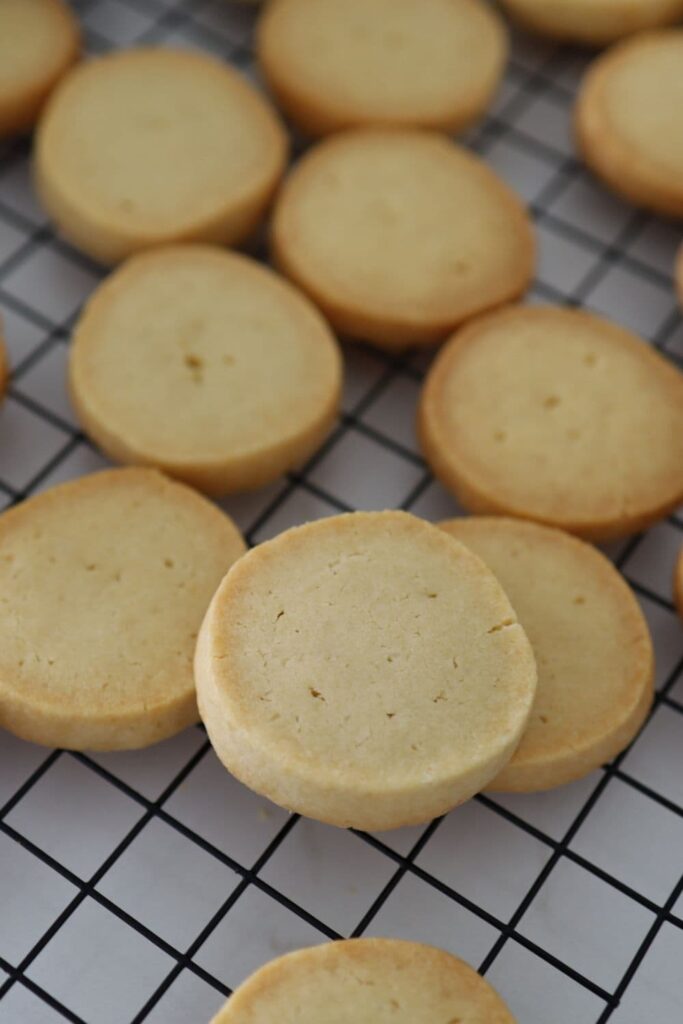 Sourdough shortbread cookies on a black wire cooling rack.