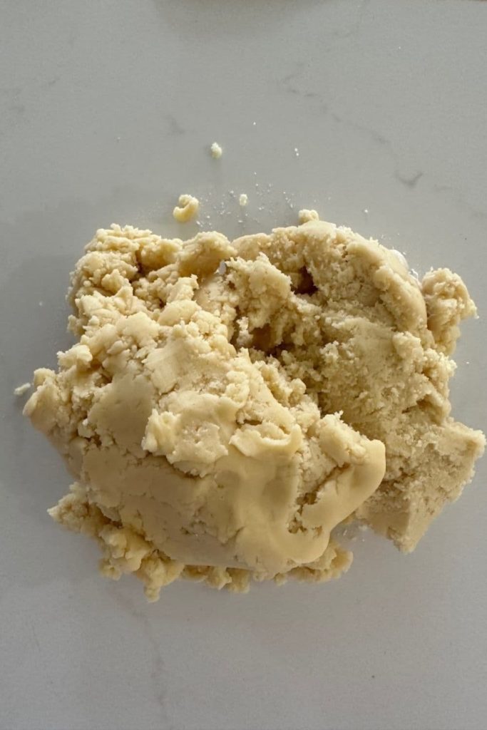sourdough shortbread cookie dough that has been brought together and tipped out onto a kitchen counter.