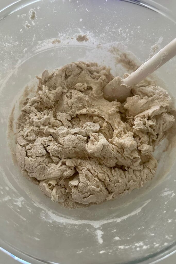 A bowl of shaggy dough that has been mixed to make a sourdough country loaf.