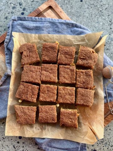 Sourdough Blondies using sourdough discard set out on a piece of parchment paper with a blue dishtowel in the background.
