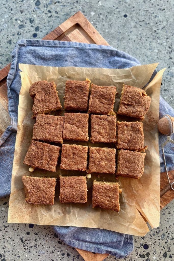 Sourdough Blondies using sourdough discard set out on a piece of parchment paper with a blue dishtowel in the background.