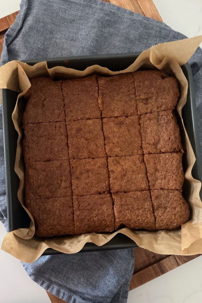 Sourdough blondies still in the tin. They have been cut into 16 equal pieces.