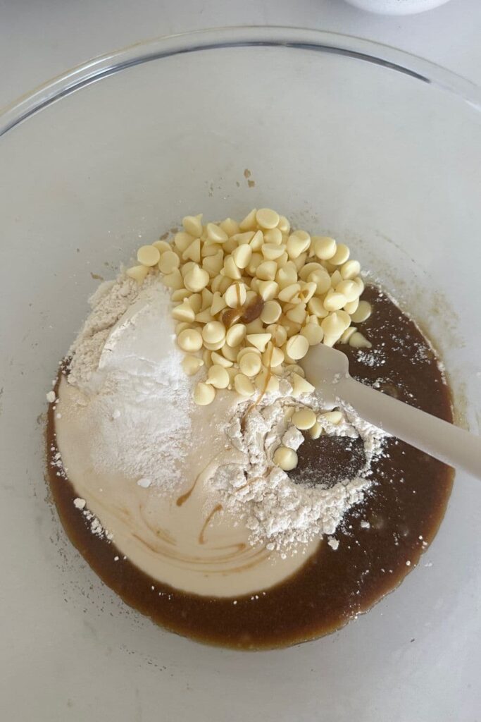 All of the dry ingredients for sourdough blondies tipped on top of the wet ingredients.