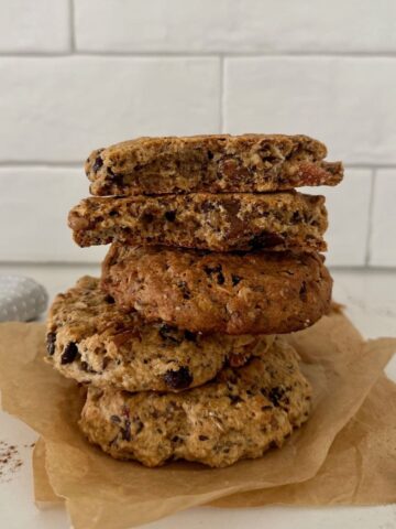 A stack of sourdough breakfast cookies sitting in front of a white tiled wall.