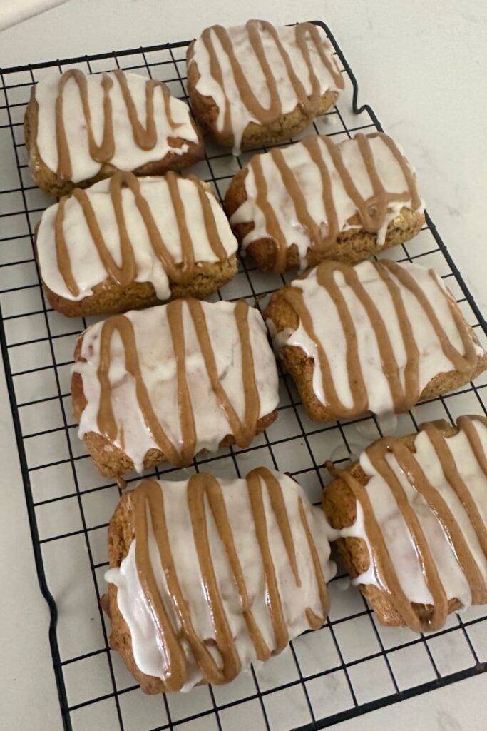 8 glazed sourdough pumpkin scones sitting on a cooling rack.