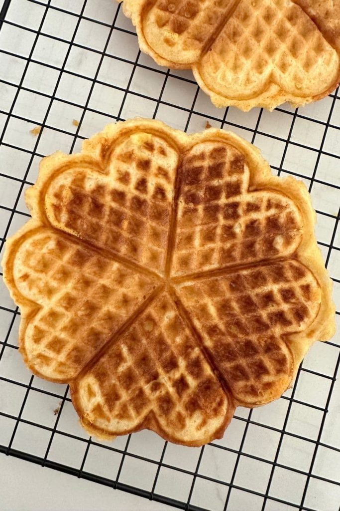 Sourdough cheese waffles cooling on a wire rack.