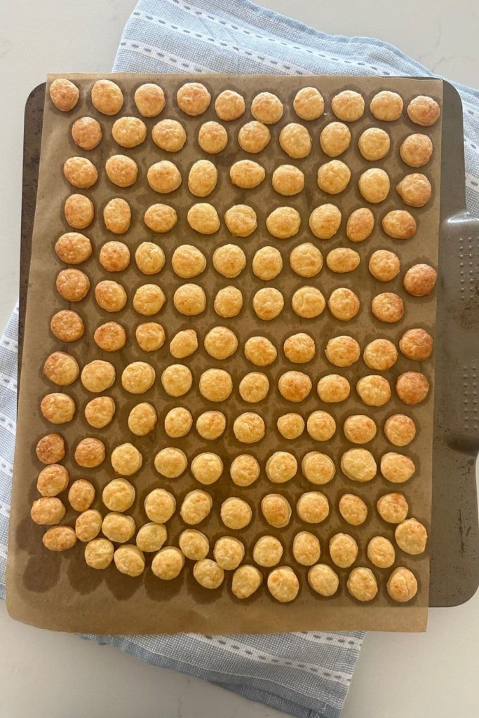 A baking tray of sourdough goldfish crackers that have just come out of the oven. They are golden brown.