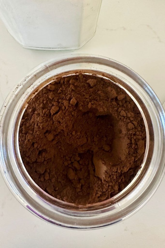 A jar of dark malt powder used in making sourdough chocolate bread.