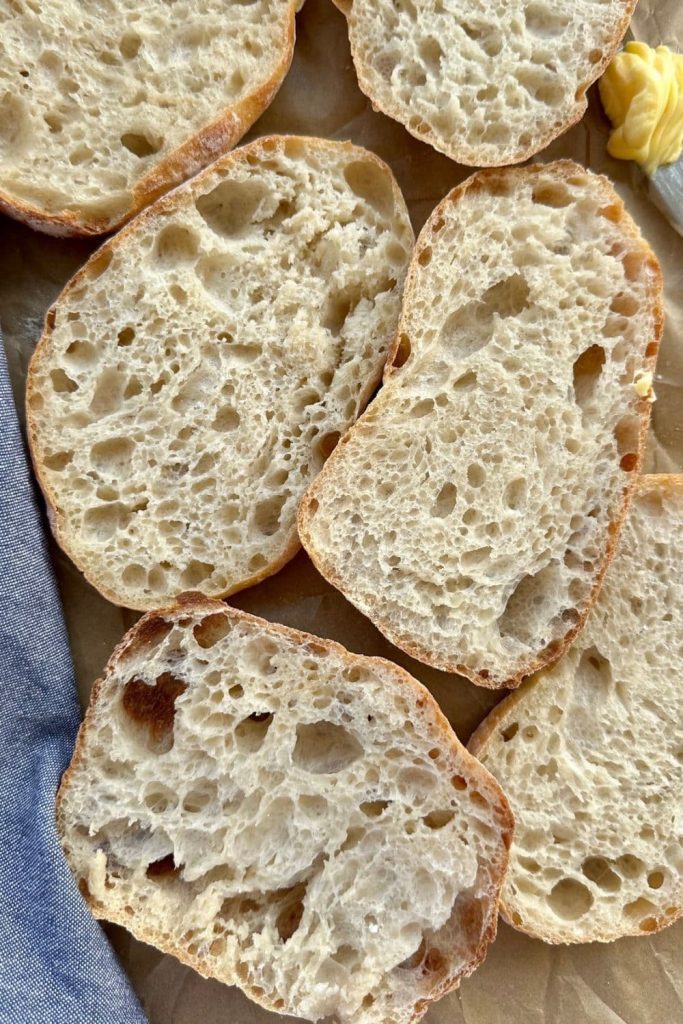 Sourdough cibatta roll that has been sliced open to reveal the open crumb structure inside.