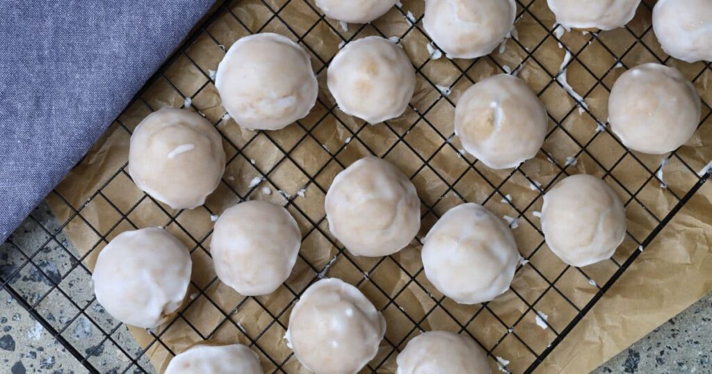 Sourdough Pfeffernusse Cookies displayed on a black wire rack.