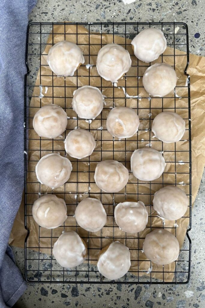 Sourdough Pfeffernusse Cookies displayed on a black wire rack.