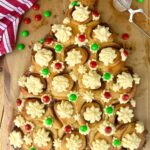 This sourdough Christmas Tree made with sourdough cinnamon rolls is one of the prettiest Christmas recipes. Cinnamon roll Christmas tree studded with vanilla cream cheese icing which has been piped on and decorated with red and green chocolate buttons.