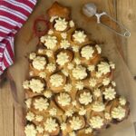 Sourdough cinnamon rolls baked in the shape of a Christmas Tree pull apart loaf. The cinnamon rolls have been iced with cream cheese Christmas stars.