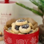 Sourdough fruit mince thumbprint cookies sitting in a red cookie tin with the word "joy" written on the front.