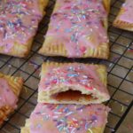 Strawberry sourdough pop tarts topped with strawberry frosting and sprinkles.