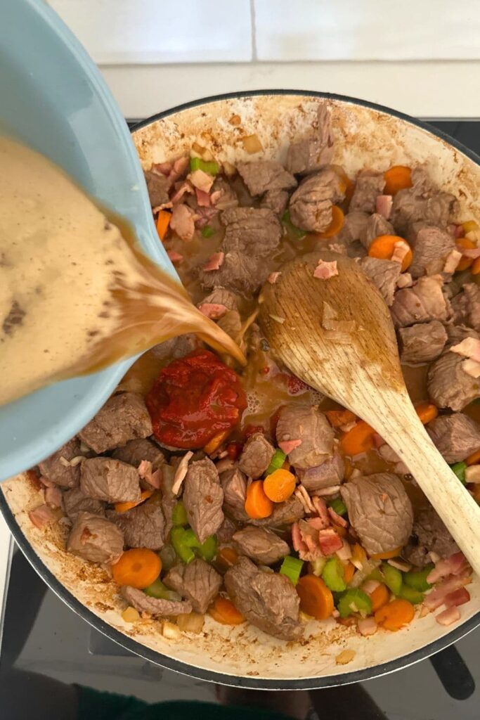 Guinness beer being poured into sourdough Irish stew.