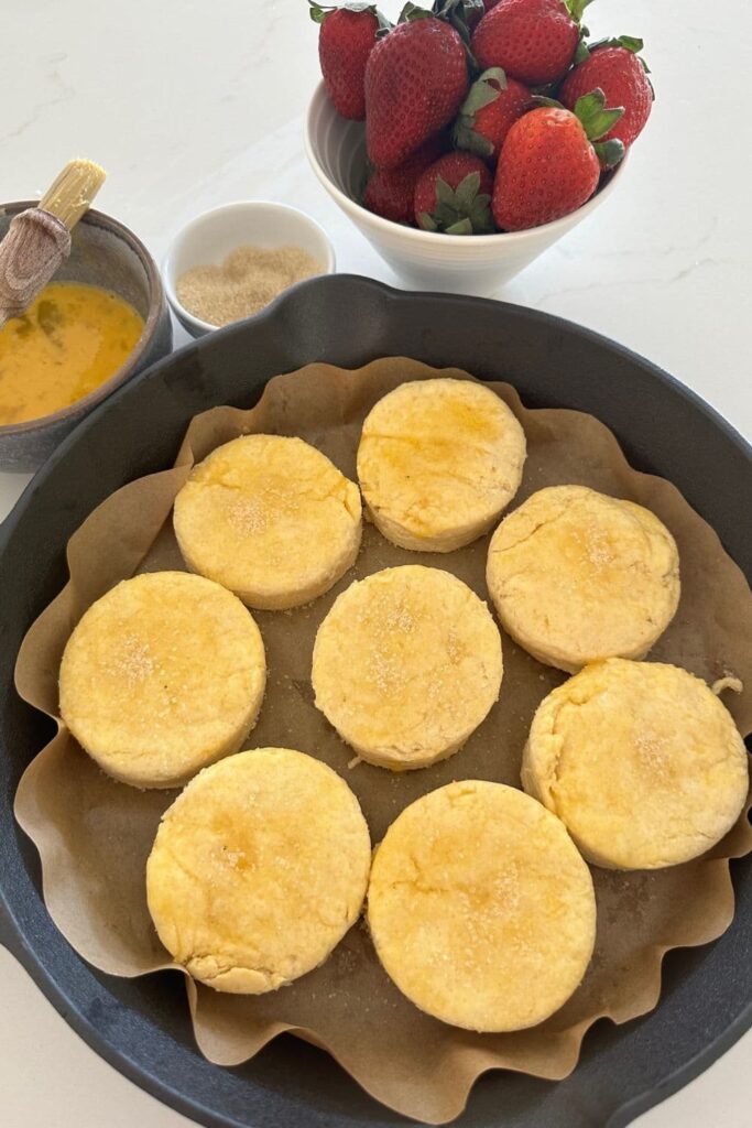 A cast iron skillet filled with flaky sourdough biscuits ready to make sourdough strawberry shortcakes.