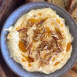 A bowl of whipped Brie butter drizzled in honey and pecans and served with sourdough Crostini.