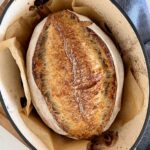 A sourdough batard straight out of the oven - it's still sitting in the Dutch oven. This photo is to demonstrate how much water weight a sourdough loaf should lose during baking time.