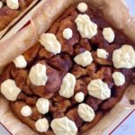 A tray of sourdough cinnamon roll focaccia bread drizzled in creamy vanilla cream cheese frosting.