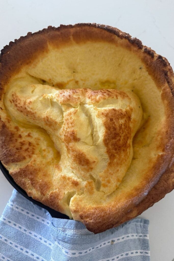 A large puffed up sourdough Dutch baby straight out of the oven.