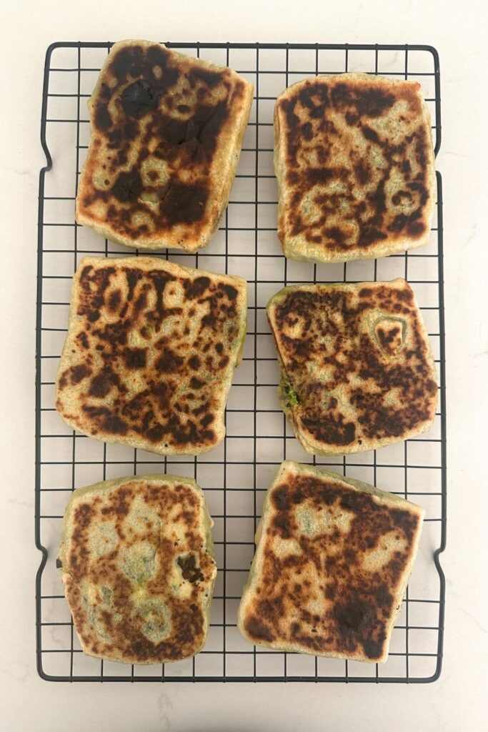 6 sourdough gozleme laid out on a black wire rack. 