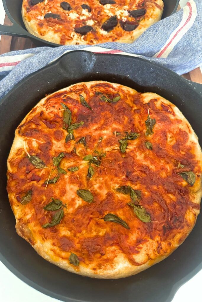 Deliciously golden sourdough pizza focaccia bread baked in a cast iron skillet.