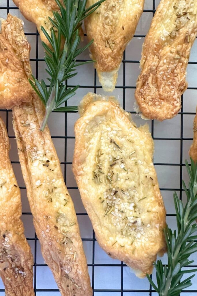 A wire cooling rack with some 2 ingredient sourdough discard crackers sitting on top. These are an example of a sourdough recipe with no added flour.