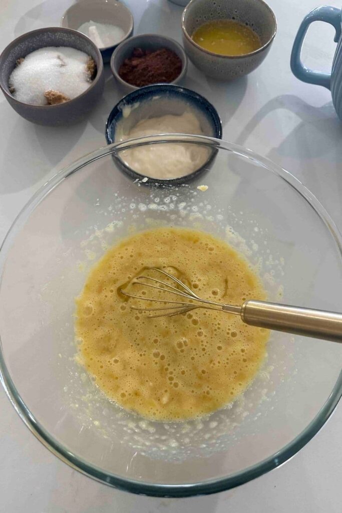 Mixing mashed bananas with eggs to make double chocolate sourdough banana bread.