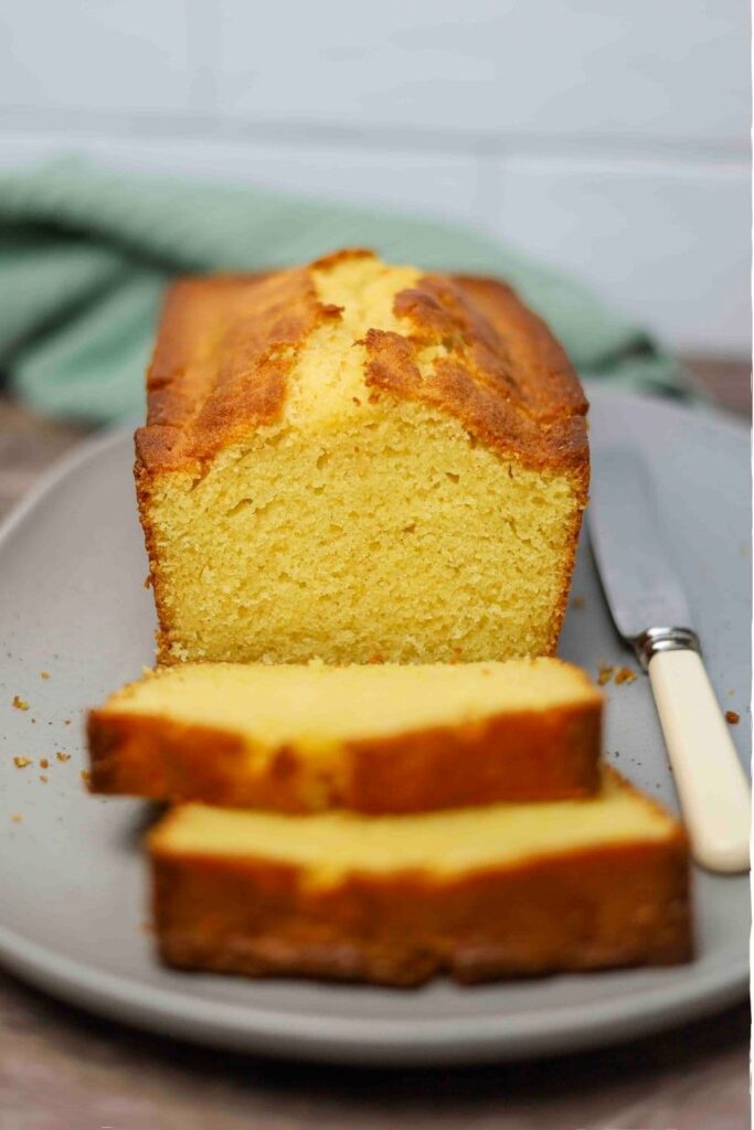 Fresh baked sourdough pound cake loaf sliced on a plate.