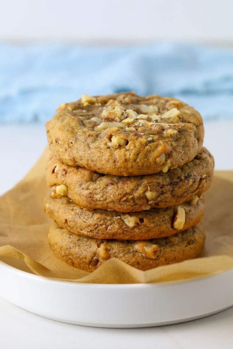 Four sourdough date and walnut cookies stacked on a plate.