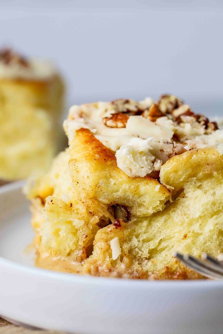 Sourdough maple pecan roll on a plate, zoomed in to show fluffy texture.