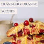 Pinterest Pin for sourdough orange and cranberry scones showing text overlay and two scones stacked on wooden plate.
