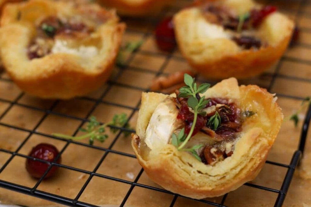 Fresh baked sourdough brie cranberry puff pastry tart on a cooling rack.
