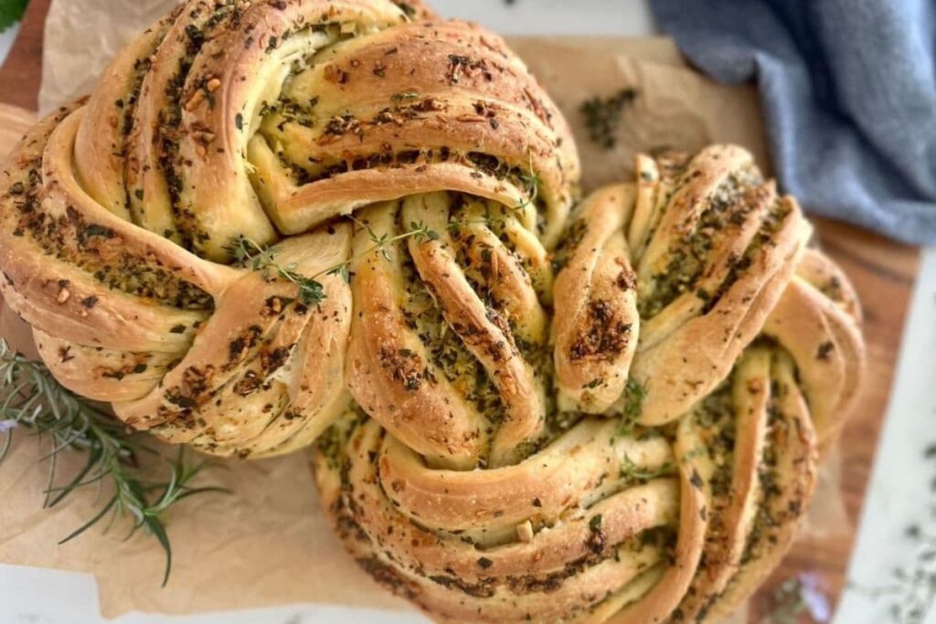Sourdough herb and garlic twist load on parchment paper.