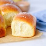 A fluffy sourdough honey butter roll topped with flaky sea salt.