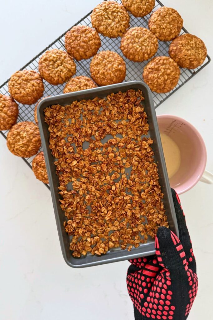 A baking sheet with toasted oats getting ready to add to sourdough honey oat cookies.