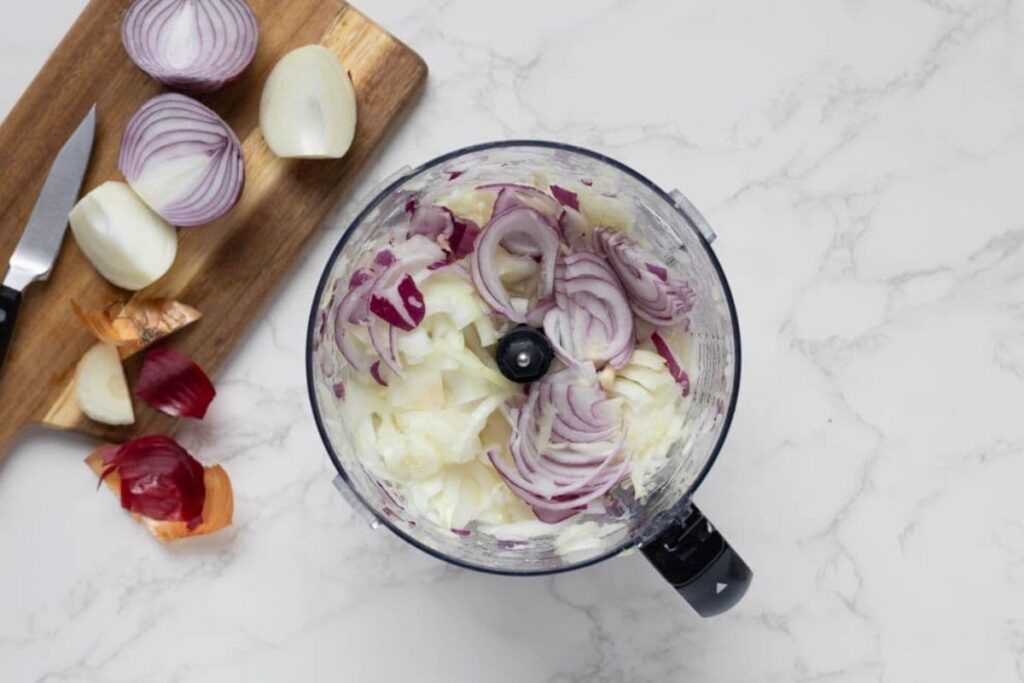 Onions in a food processor to show an easier method to chop them to make caramelized onion relish.