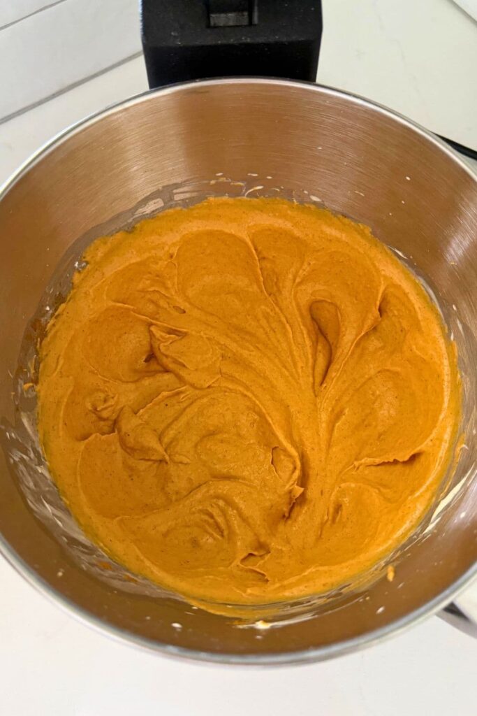 Whipped pumpkin pie dip in the bowl of a stainless steel stand mixer.