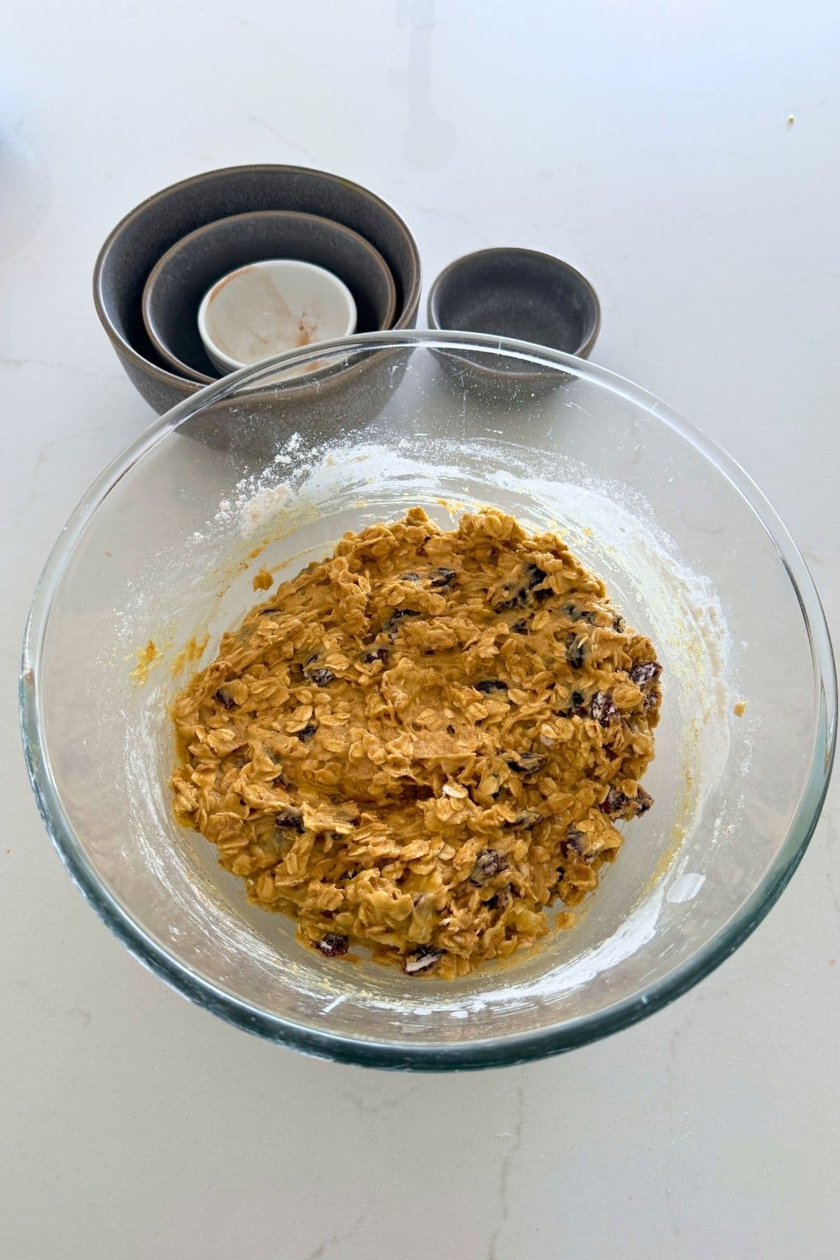 Mix dough in a bowl for orange cranberry sourdough oatmeal cookies.