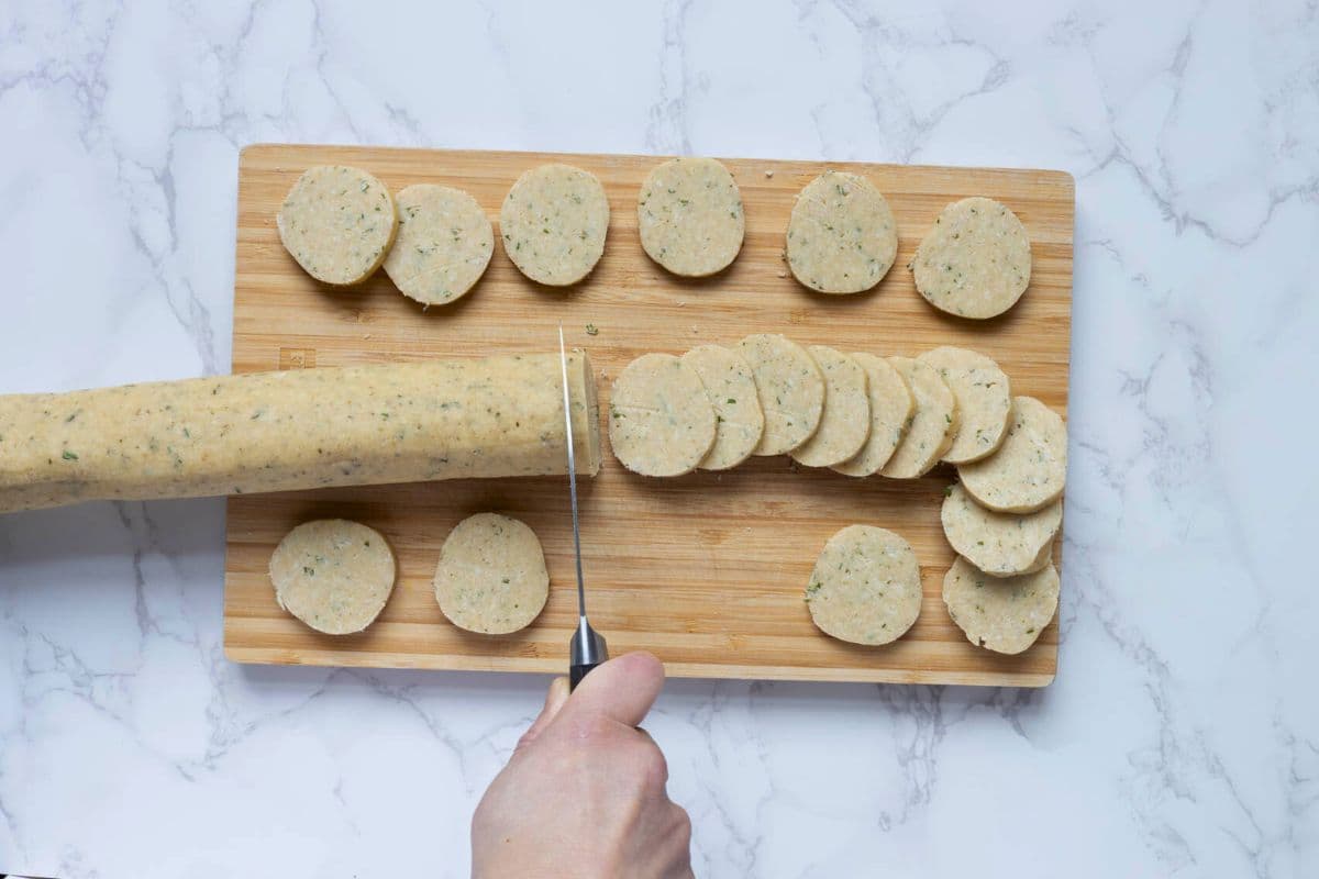 Slicing the sourdough discard rosemary and parmesan shortbread dough to make the biscuits.