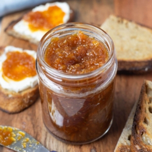 A jar of freshly made carrot cake jam on a serving platter.